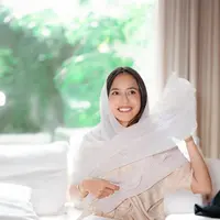 Penampilan Pevita Pearce di foto ini bisa kamu jadikan inspirasi outfit bukber. Ia tampil mengenakan gamis lengan pendek yang mengkilap, menambah nuansa mewah pada tampilan yang sederhana. Pevita menambahkan selendang putih polos untuk menutupi kepalanya. [Foto: Instagram/pevpearce]