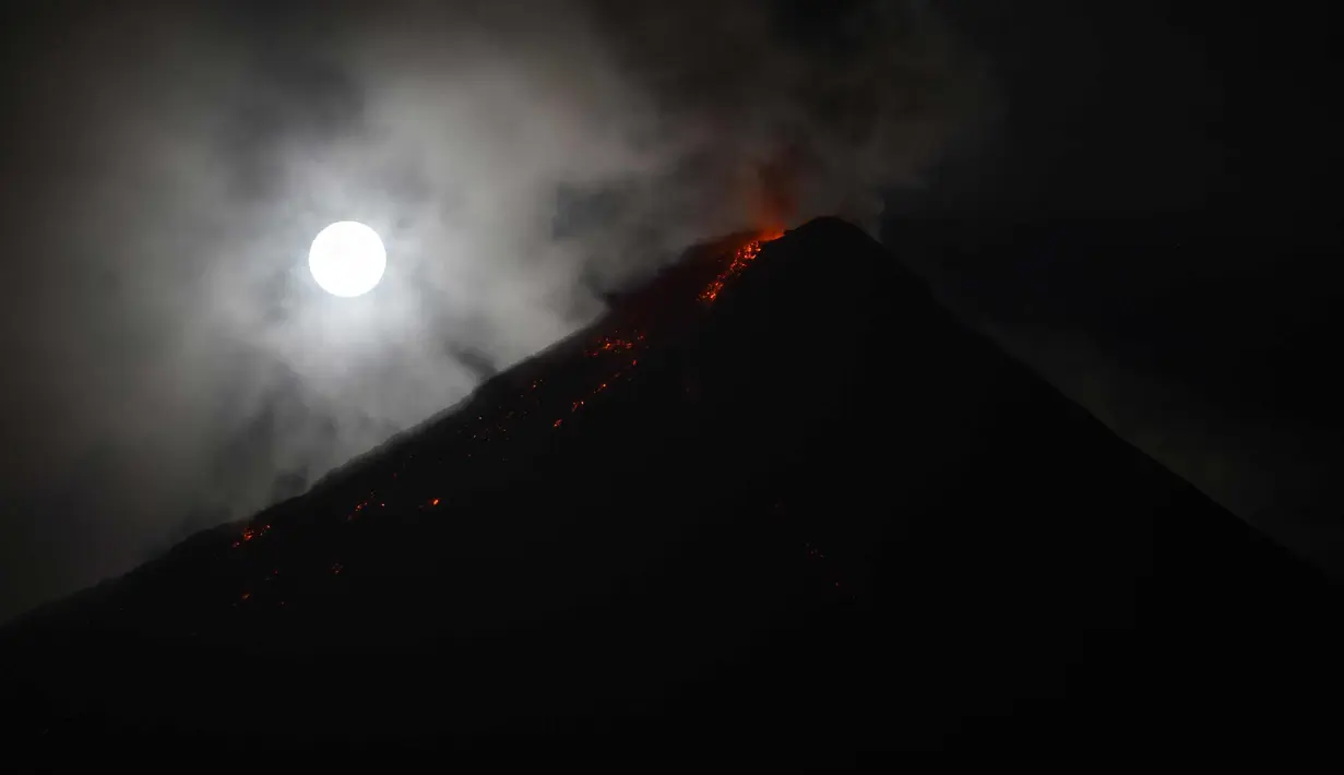 Gerhana bulan "super blue blood moon" terlihat di samping Gunung Mayon yang mengeluarkan lava panas di Legazpi, Filipina (1/2). Pemandangan supermoon di mana bulan berada di jarak terdekat dengan bumi terlihat di sejumlah negara. (AFP Photo/Ted Aljibe)
