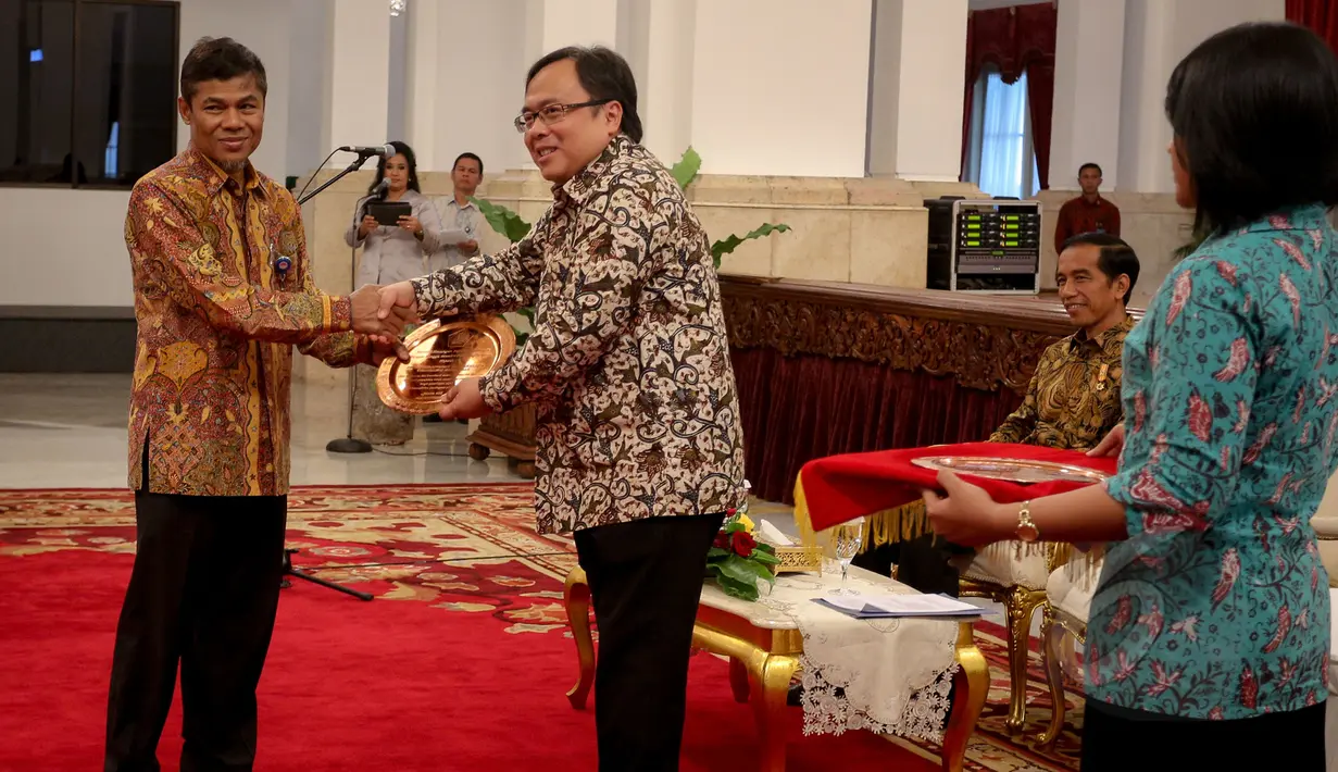 Menkeu Bambang Brodjonegoro memberikan penghargaan kepada Kepala PPATK Muhammad Yusuf pada acara pemberian penghargaan dalam rangka penerimaan pajak 2015 dari Kementerian Keuangan di Istana Negara, Jakarta, Rabu (20/5). (Liputan6.com/Faizal Fanani)