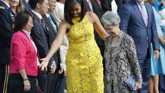 Ho Ching terlihat membawa tas tangan bermotif dinosaurus biru dan putih pada upacara di White House. (AP)