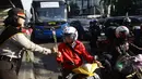 Para pengendara motor di kawasan Slipi mendapat bunga dari seorang Polwan, Jakarta, Selasa (21/4/2015). Pembagian bunga ini dalam rangka memperingati hari Kartini.(Liputan6.com/Johan Tallo)