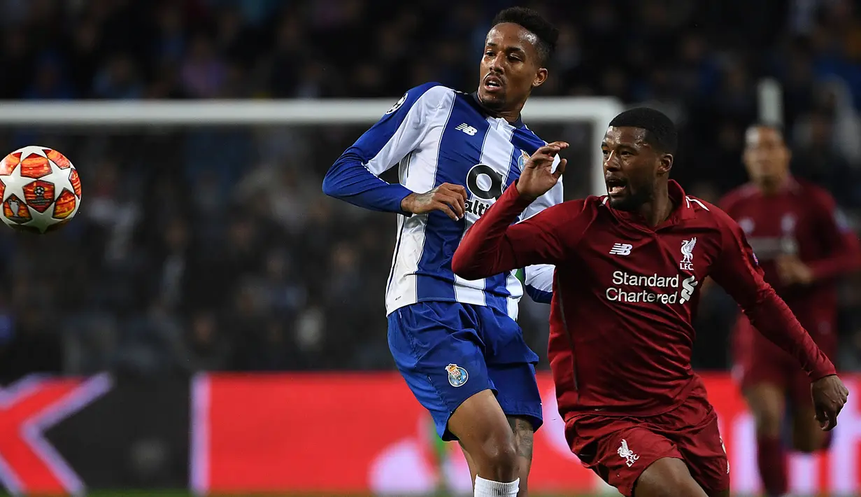 Gelandang Liverpool, Georginio Wijnaldum berebut bola dengan pemain FC Porto, Eder Militao pada leg kedua perempat final Liga Champions 2018/2019 di Estadio do Dragao, Rabu (17/4). Liverpool memastikan lolos ke babak semifinal setelah membantai Porto 4-1. (PATRICIA DE MELO MOREIRA / AFP)