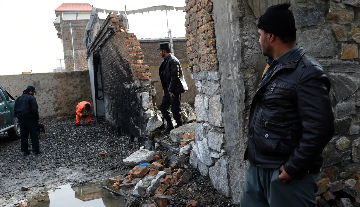 Sejumlah petugas melakukan investigasi di lokasi ledakan bom mobil di sebuah restoran Prancis di Kabul, Afganistan, Sabtu (2/1/2016). Akibatnya, dua orang tewas dan 15 lainnya luka-luka. (AFP PHOTO/Wakil Kohsar)