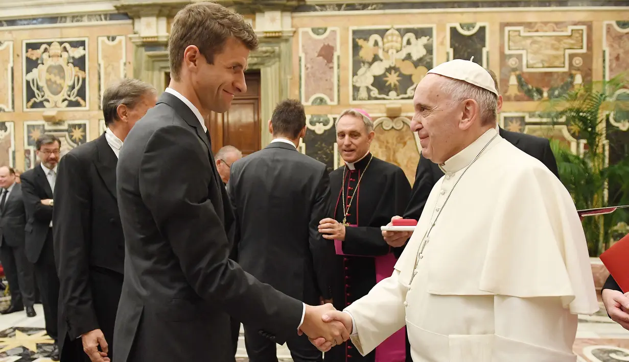 Paus Fransiskus (kanan) berjabat tangan dengan pemain Timnas Jerman, Thomas Muller selama audiensi pribadi dengan tim, pada tanggal 14 November 2016 di Vatikan. (AFP/Pool/Markus Gilliar)
