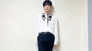 Tampil dengan kemeja putih yang dipadukan celana hitam, penampilan Jin BTS ini terlihat begitu menawan. Terlebih lagi, ornamen bunga pada bagian bahu membuat penampilan pria 29 tahun ini semakin terlihat memesona. (Liputan6.com/IG/@jin)