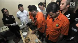 Tersangka menunjukkan proses pembuatan liquid vape narkoba di Kelapa Gading, Jakarta, Rabu (31/10). Polisi menyita barang bukti berupa liquid vape narkoba, rokok elektrik, dan sebuah mobil. (Merdeka.com/Iqbal Nugroho)