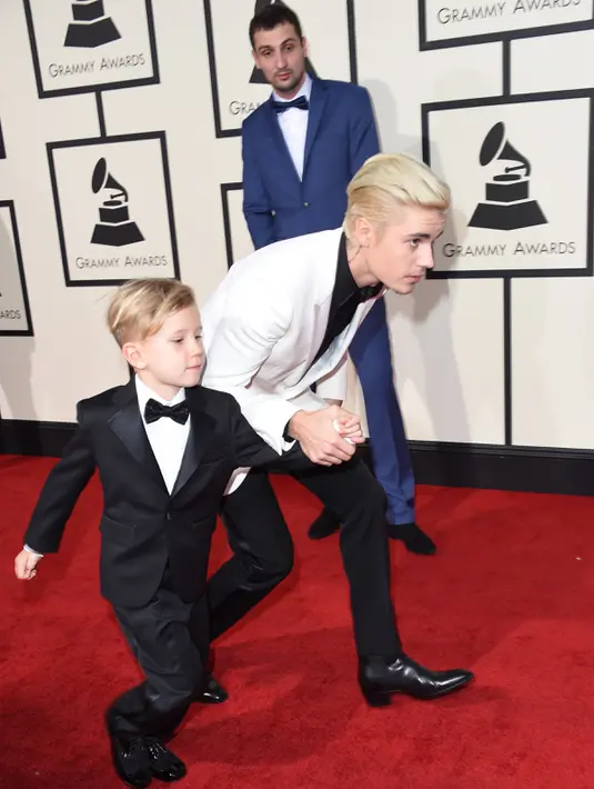 Penyanyi Justin Bieber dan adiknya, Jaxon, berjalan di karpet merah Grammy Awards 2016 di Staples Center, Los Angeles, Senin (15/2). Mantan kekasih Selena Gomez itu tampil kompak dengan sang adik yang juga mengenakan setelan jas. (AFP PHOTO/VALERIE MACON)