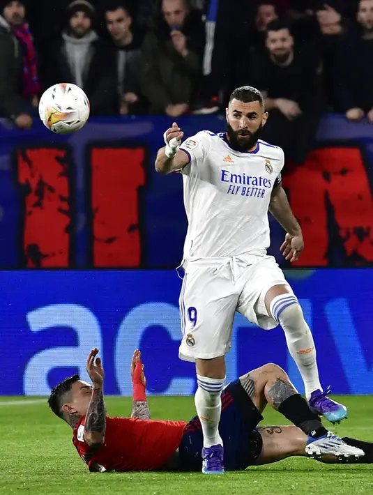 Pemain Real Madrid Karim Benzema (kanan) berebut bola dengan pemain Osasuna Chimy Avila pada pertandingan sepak bola La Liga Spanyol di Stadion El Sadar, Pamplona, Spanyol, 20 April 2022. Real Madrid menang 3-1. (AP Photo/Alvaro Barrientos)
