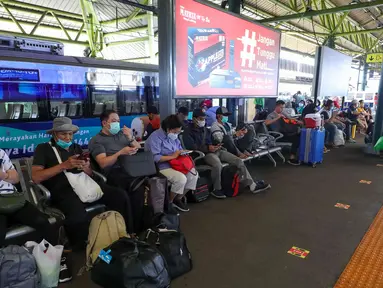 Calon penumpang menunggu kereta api di Stasiun Gambir, Jakarta, Jumat (22/4/2022). Stasiun Gambir per Jumat (22/4/2022) terdapat 33 KA beroperasi, dari jumlah tersebut 7 diantaranya merupakan KA tambahan. (Liputan6.com/Herman Zakharia)