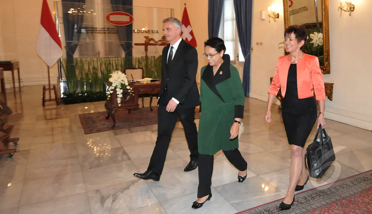 Menlu Retno L.P. Marsudi mengajak rombongan Menlu Swiss Didier Burkhalter ke ruang yang telah disiapkan, Jakarta, Senin (16/3/2015). Keduanya bertemu untuk membahas berbagai isu bilateral antar kedua negara. (Liputan6.com/Johan Tallo) 