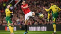 Gelandang Manchester United, Nemanja Matic, berebut bola dengan bek Norwich, Max Aarons, pada laga Premier League di Stadion Old Trafford, Manchester, Sabtu (11/1). MU menang 4-0 atas Norwich. (AFP/Oli Scarff)