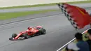Pebalap Ferrari, Sebastian Vettel melintasi jalur dengan dukungan suporter pada balapan Formula One Malaysia Grand Prix, Sepang, (01/10/2017). Vettel akhirnya finis pada posisi keempat. (AFP/Roslan Rahman)