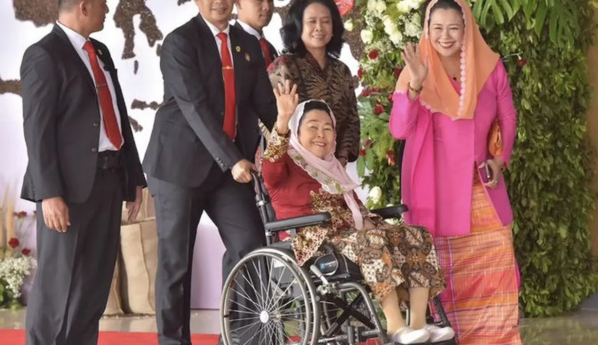 Yenny Wahid tampil dengan kebaya pink dipadukan kerudung dan kain bawahan warna oranye.  [Instagram/@sekretariat.kabinet]