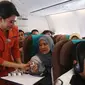 Pramugari membagikan cokelat kepada penumpang dalam penerbangan di Pesawat Garuda Indonesia menuju, Padang, Sumatera Barat, Jumat (21/4). Dalam rangka menyambut Hari Kartini, penerbangan Garuda Indonesia diawaki oleh perempuan. (Liputan6.com/Angga Yuniar)