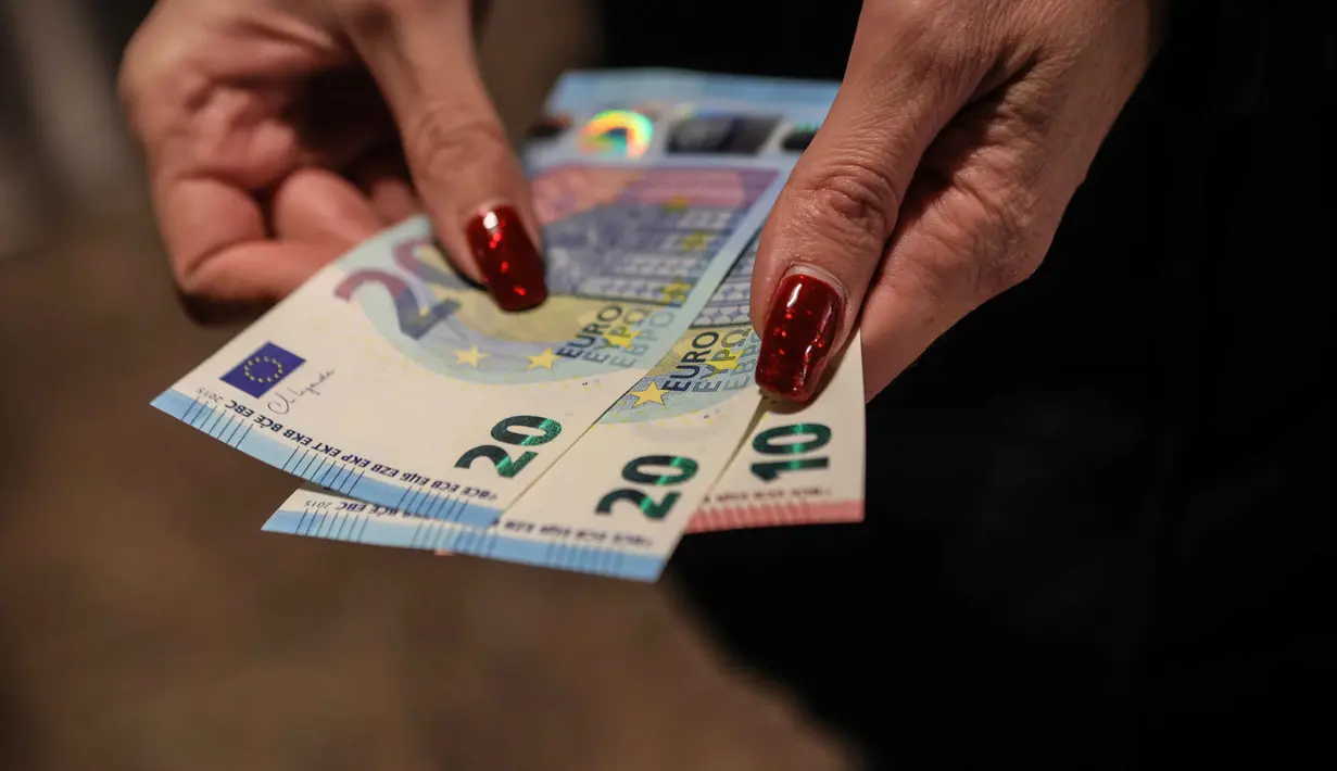 Seseorang menunjukkan uang kertas euro yang ditarik dari ATM di Sofia, Bulgaria, Kamis 1 Januari 2026, saat negara tersebut bergabung dengan serikat mata uang euro. Bulgaria resmi memasuki era baru kebijakan moneter dengan mengadopsi euro sebagai mata uang nasional. (AP Photo/Valentina Petrova)