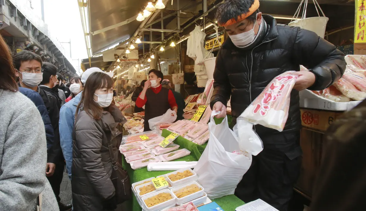 Orang-orang yang memakai masker mengunjungi shopping street Ameyoko untuk membeli bahan masakan Tahun Baru di Tokyo, Selasa (29/12/2020). Tokyo melaporkan peningkatan kasus COVID-19 menjelang musim libur tahun baru, dimana biasanya warga yang tinggal di ibu kota akan mudik. (AP Photo/Koji Sasahara)