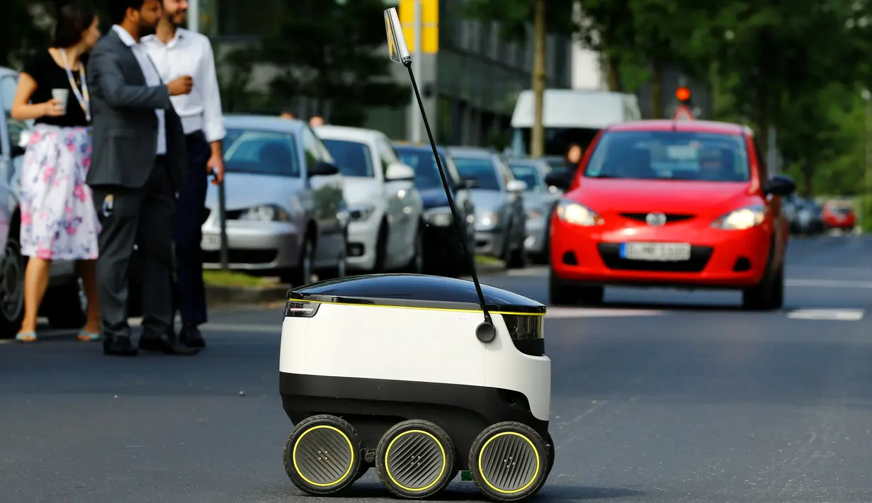 Mobil mungil beroda enam buatan Starship Technologies melintasi jalanan saat demonstrasi di kantor pusat Metro, Jerman, Selasa (7/6). Untuk keamanan, penutup robot ini hanya bisa dibuka melalui perangkat mobile para pelanggannya. (REUTERS/Wolfgang Rattay)