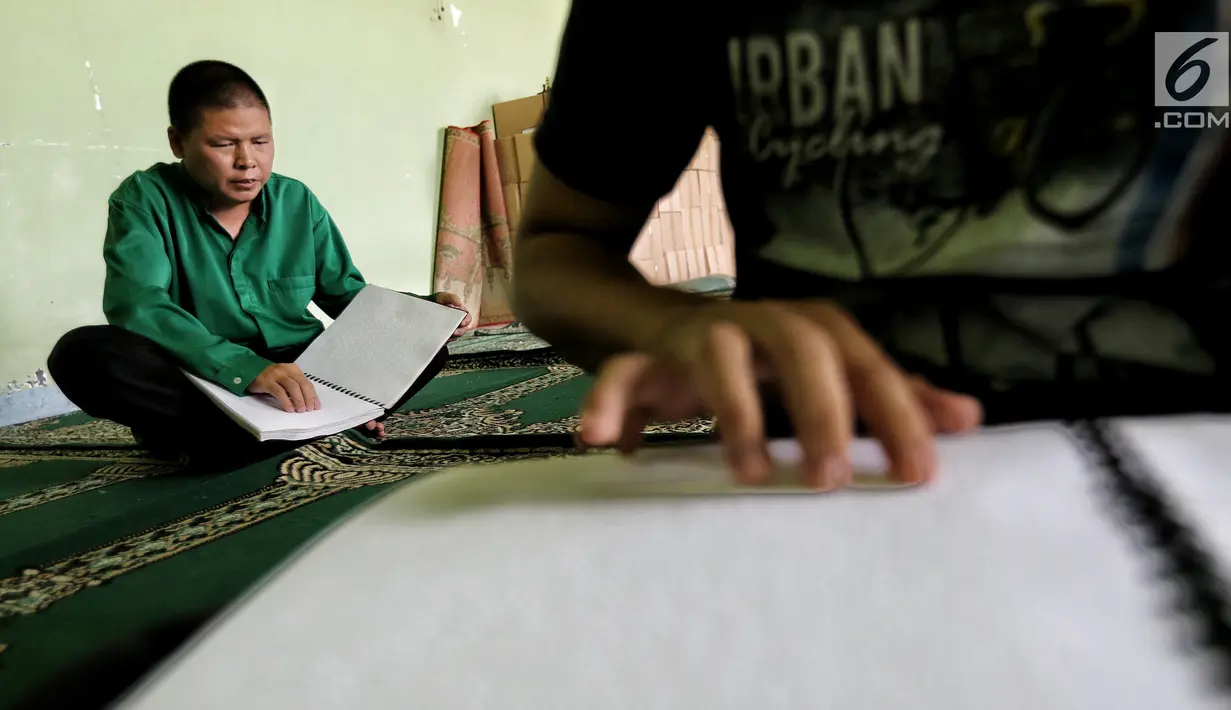 Dua santri penyandang tunanetra membaca Al Quran Braille di Yayasan Raudlatul Makfufin, Tangerang Selatan, Kamis (24/5). Yayasan yang berdiri sejak tahun 1983 ini memproduksi Al Quran Braille sebanyak 60 buku setiap harinya. (Liputan6.com/Fery Pradolo)