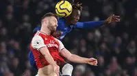 Bek Arsenal, Shkodran Mustafi berebut bola dengan striker Chelsea, Tammy Abraham pada lanjutan pertandingan Liga Inggris di Stamford Bridge, Selasa (21/1/2020). Chelsea gagal memetik hasil maksimal usai ditahan Arsenal dengan skor 2-2. (DANIEL LEAL-OLIVAS / AFP)