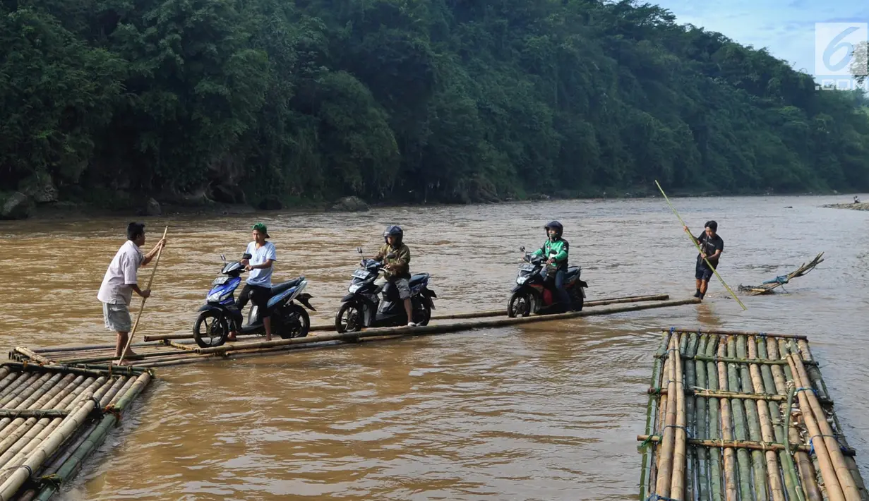Sebuah rakit mengangkut motor dan warga menyeberangi Sungai Cisadane di Rumpin, Bogor, Selasa (13/3). Mereka terpaksa menaiki rakit akibat jembatan Gerendong yang merupakan akses jalan utama Ciseeng -Rumpin masih dalam perbaikan. (Merdeka.com/Arie Basuki)