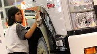 Seorang pekerja membersihkan truk agar terus tampil kinclong