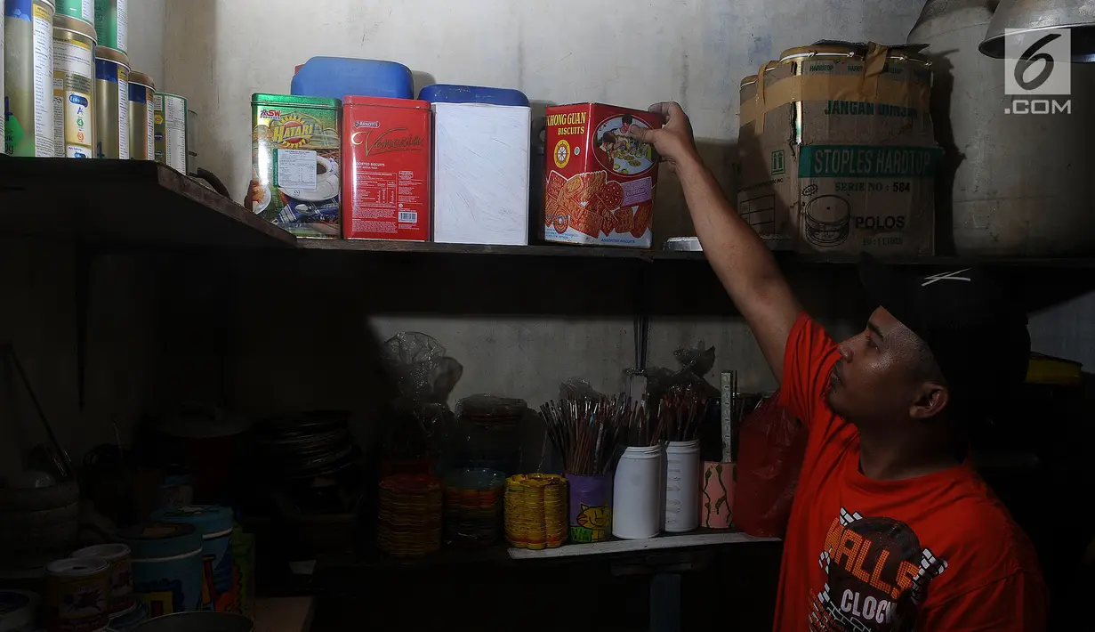 Perajin  mengambil sampah kaleng bekas untuk dilukis di Tanah Baru Depok, Jawa Barat, Rabu (13/2). Lukisan dengan media kaleng bekas tersebut selain hobi dan bisnis juga ikut menjaga kelestarian alam. (Liputan6.com/Herman Zakharia)