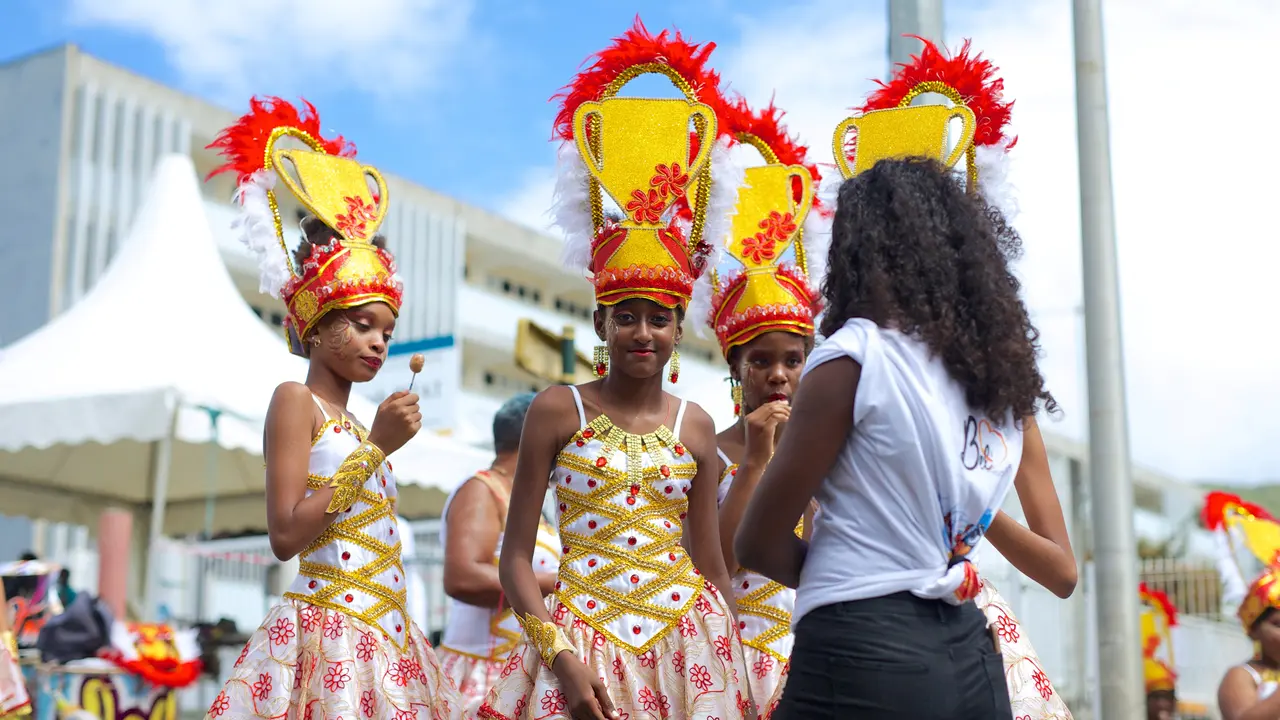 Orang-orang yang bersuka ria menunggu dimulainya parade karnaval di Basse-Terre di pulau Guadeloupe di seberang laut Prancis