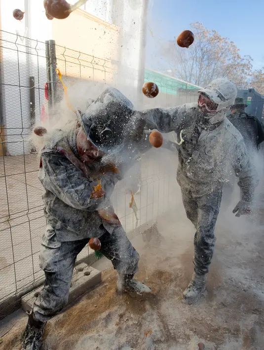 <p>Orang-orang yang bersuka ria mengenakan pakaian militer tiruan saat ikut serta dalam perang makanan "Els Enfarinats" di Kota Ibi, Spanyol, 28 Desember 2022. (JAIME REINA/AFP)</p>