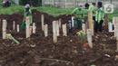 Petugas merapikan area makam jenazah dengan protokol COVID-19 di TPU Srengseng Sawah, Jakarta, Kamis (21/1/2021). Sebagian lahan TPU Srengseng Sawah dijadikan pemakaman jenazah Covid-19 sejak Selasa (12/1) lalu, dengan kapasitas 564 petak makam kini nyaris penuh. (Liputan6.com/Helmi Fithriansyah)