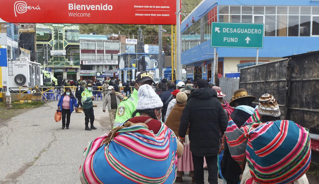 Warga Peru antre memasuki perbatasan Bolivia untuk memasuki negara tersebut, di desa Desaguadero, Peru, pada 18 Februari 2022. Setelah ditutup selama hampir dua tahun karena pandemi Covid-19, Pemerintah Peru mengizinkan pembukaan kembali perbatasan dengan Bolivia dan Ekuador. (Carlos MAMANI/AFP)