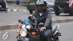 Seorang warga mengendarai motor bersama dua ekor monyet peliharaanya di kawasan Senayan, Jakarta, Kamis (1/12). Populasi monyet jenis ini cenderung masih banyak, dan sering dijadikan hewan peliharaan. (Liputan6.com/Helmi Affandi)