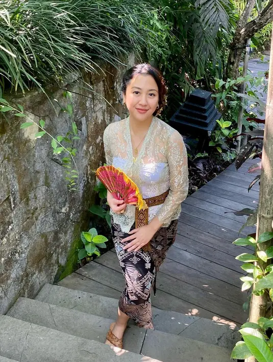 Sematan belt emas dan gaya Sherina yang memegang kipas hadirkan pesona bak Gadis Bali [@sherinamunaf]