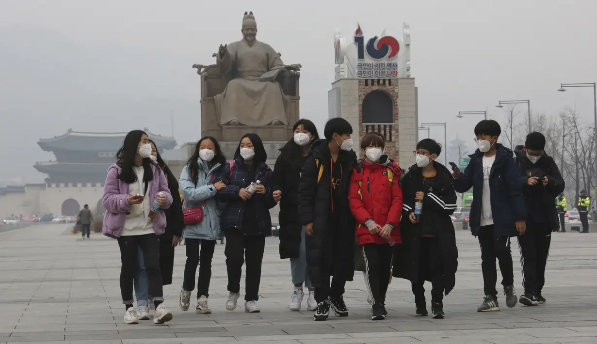 Para siswa mengenakan masker berjalan di Gwanghwamun Plaza di Seoul, Korea Selatan (10/12/2019). Kementerian Lingkungan Hidup Korsel menegakkan serangkaian tindakan darurat untuk mengurangi polusi debu halus, termasuk melarang kendaraan tertentu dari jalan pusat kota. (AP Photo/Ahn Young-joon)
