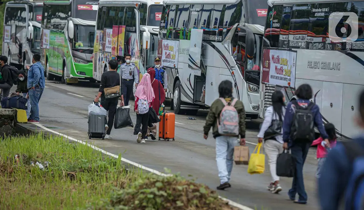 <p>Peserta Mudik Aman Mudik Sehat Kementerian Perhubungan membawa barang bawaan mereka berjalan menuju bus tujuan kampung halamannya di Terminal Jatijajar, Depok, Jawa Barat, Kamis (28/4/2022). Pengguna jasa transportasi bus yang mengikuti program mudik gratis didominasi oleh pemudik yang berasal dari Jawa Tengah dan Jawa Timur dengan syarat telah menerima vaksin booster. (Liputan6.com/Faizal Fanani)</p>