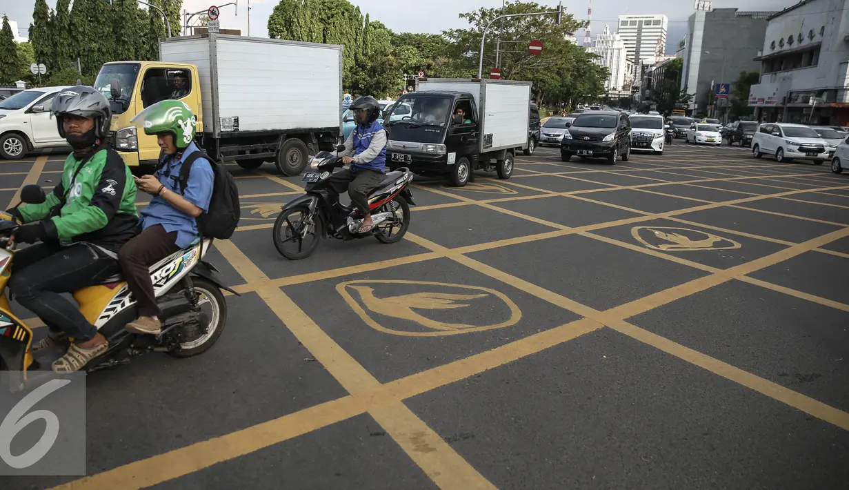Sejumlah kendaraan melintasi Yello Box Junction berlambang burung dikawasan Harmoni, Jakarta, Rabu (27/4/2016). Yellow box junction tersebut merupakan bagian dari program corporate social responsibility (CSR) dari Blue Bird. (Liputan6.com/Faizal Fanani)