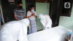 Tim relawan dari Polmas Bogor mengurus jenazah warga korban COVID-19 yang meninggal saat isolasi mandiri di Bogor, Jawa Barat, Jumat (9/7/2021). Dalam sehari, relawan menangani lima hingga delapan jenazah warga Kota Bogor yang meninggal karena COVID-19 saat isolasi mandiri. (merdeka.com/Arie Basuki)