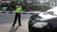 Polisi menghentikan mobil saat pemberlakuan ganjil genap di kawasan Fatmawati, Jakarta, Senin (25/10/2021). Sistem ganjil genap di DKI Jakarta berlaku pada hari Senin hingga Jumat pada pukul 06.00-10.00 WIB dan 16.00-20.00 WIB. (Liputan6.com/Herman Zakharia)