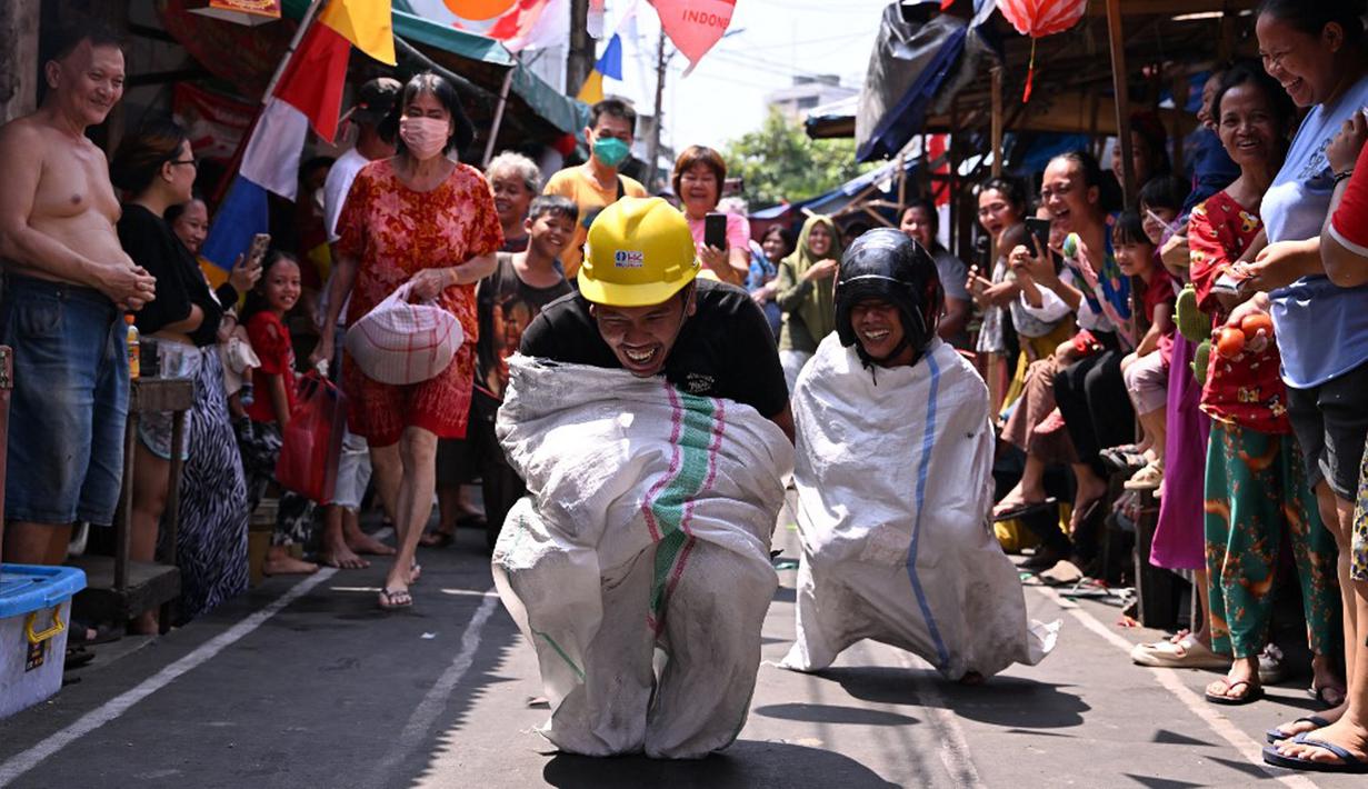 Warga mengikuti lomba lari karung dalam rangka memperingati Hari Ulang Tahun (HUT) ke-78 Republik Indonesia (RI) di Jakarta, Kamis (17/8/2023). (ADEK BERRY/AFP)