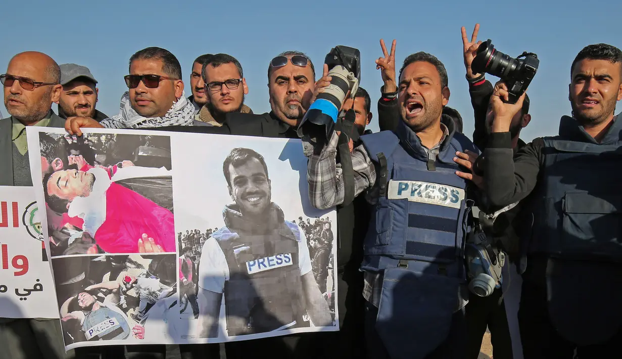 Sejumlah wartawan Palestina menggelar aksi protes terkait pembunuhan wartawan Yasser Murtaja di dekat perbatasan Israel-Gaza, Palestina (8/4). Yasser Murtaja tewas dengan luka tembak saat meliput aksi protes warga Palestina. (AFP Photo/Said Khatib)