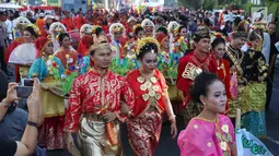 Sejumlah peserta mengenakan baju adat saat mengikuti parade ASEAN 50 Tahun di Jakarta, Minggu (27/8). Acara ini merupakan pertunjukan keragaman budaya di Asia Tenggara yang bersatu guna memperingati 50 tahun ASEAN berdiri. (Liputan6.com/Angga Yuniar)