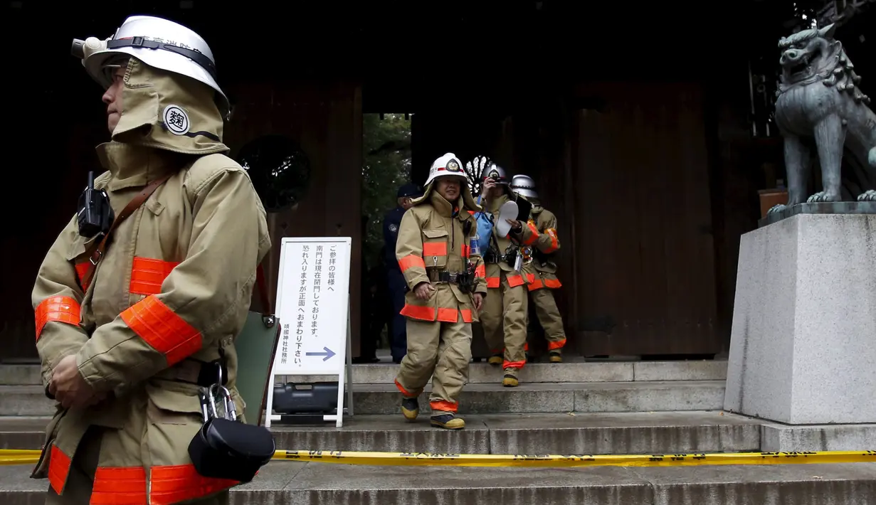 Petugas pemadam kebakaran saat memeriksa gerbang selatan Yasukuni Shrine dimana ledakan terjadi, Tokyo, Jepang, (23/11). Tidak ada korban jiwa dalam peristiwa ini. (REUTERS/Toru Hanai)