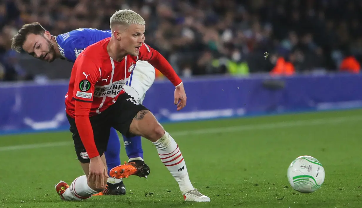 Gelandang Leicester City James Maddison berebut bola dengan bek PSV Eindhoven Philipp Max pada leg pertama perempatfinal Europa Conference League di King Power Stadium, Jumat (8/4/2022) dini hari WIB. Leicester City ditahan imbang 0-0 saat menjamu PSV Eindhoven. (Geoff Caddick / AFP)