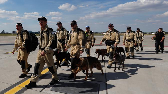 Anggota tim SAR Ceko beserta anjing pelacak berjalan menaiki pesawat di bandara Vaclav Havel di Praha, Rabu (5/8/2020). Republik Ceko mengirimkan sekitar 37 personel dan lima ekor anjing pelacak untuk membantu pencarian korban ledakan dahsyat di Beirut, Lebanon. (AP Photo/Petr David Josek)