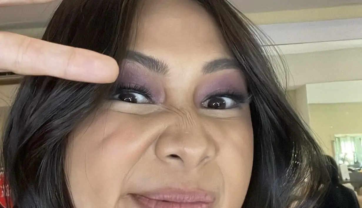 Saat mengenakan mini dress batik tersebut, Niki mengaplikasikan eye shadow ungu shimmer pada riasan matanya, blush on pink tipis dan lipstik nude matte menghiasi wajahnya. [@nikizefanya]