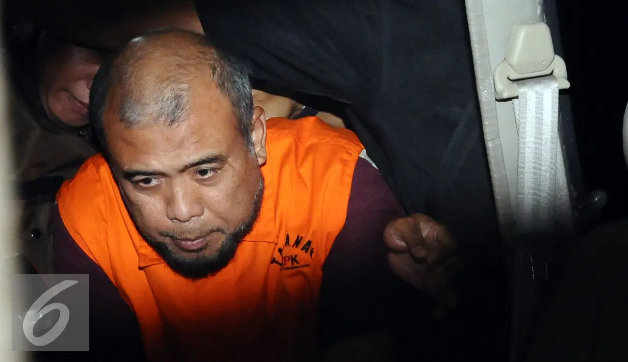 Hakim Mahkamah Konstitusi, Patrialis Akbar saat masuk mobil tahanan usai diperiksa KPK, Jakarta, Jumat dini hari (27/1). Patrialis diduga menerima suap uji materi undang-undang tentang peternakan dan kesehatan hewan. (Liputan6.com/Helmi Fithriansyah)