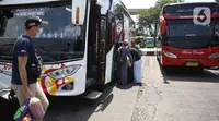 Calon penumpang bersiap menaiki bus di Terminal Kampung Rambutan Jakarta, Kamis (24/3/2022). Pemerintah memastikan bahwa masyarakat diperbolehkan mudik Lebaran tahun 2022 dengan syarat sudah mendapatkan vaksin dosis lengkap dan ketiga atau booster. (Liputan6.com/Herman Zakharia)