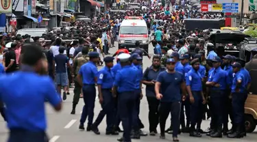 Polisi mensterilkan jalan saat sebuah ambulans melaju membawa korban ledakan gereja di Kochchikade, Kolombo, Sri Lanka, Minggu (21/4). Sekitar 99 orang dilaporkan tewas dalam ledakan di tiga gereja dan tiga hotel di Sri Lanka. (AP Photo/Eranga Jayawardena)