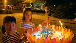 Anak-anak membawa sebuah lentera air untuk dihanyutkan dalam Festival Loy Krathong di Bandar Seri Begawan, Brunei (31/10/2020).  Sekitar 250 orang termasuk sejumlah warga Thailand yang tinggal di Brunei menghanyutkan lentera air untuk perdamaian dan keberuntungan. (Xinhua/Jeffrey Wong)