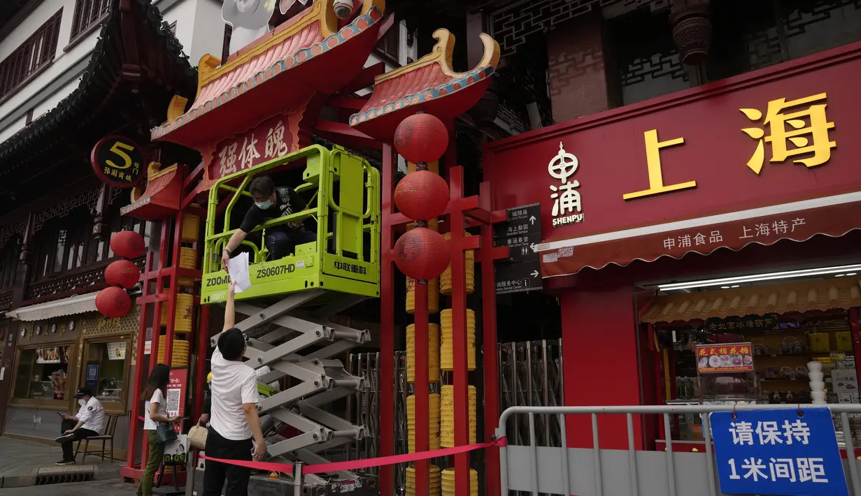 Pekerja melakukan perawatan di Yu Garden Mall di Shanghai (2/6/2022). Lalu lintas, pejalan kaki dan pelari muncul kembali di jalan-jalan Shanghai ketika kota terbesar di China mulai kembali normal di tengah pelonggaran penguncian COVID-19 dua bulan yang ketat atas penerapannya. (AP Photo/Ng Han Guan)