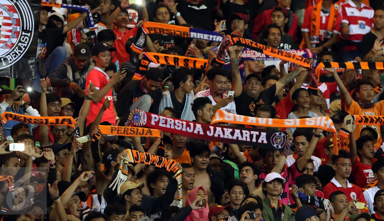 Suporter membentangkan syal usai menyaksikan laga Persija melawan Timnas Indonesia U-22 di Stadion Patriot Candrabhaga, Bekasi, Rabu (5/4). Laga Persija melawan Timnas Indonesia U-22 berakhir imbang 0-0. (Liputan6.com/Helmi Fithriansyah)